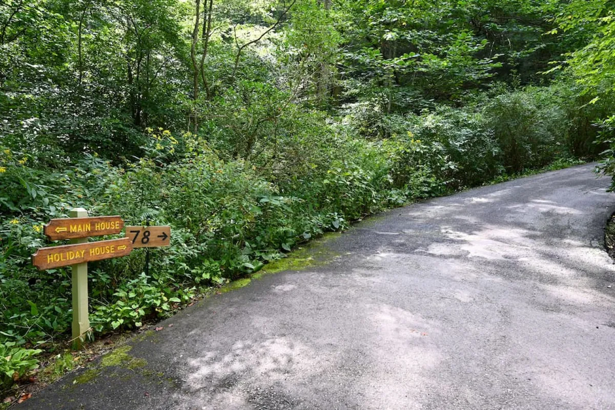 This inviting image shows a signpost and a picturesque pathway winding through greenery, suggesting adventure, exploration, and discovery. The scene hints at the opportunities for nearby walks, nature exploration, and easy access to local attractions.