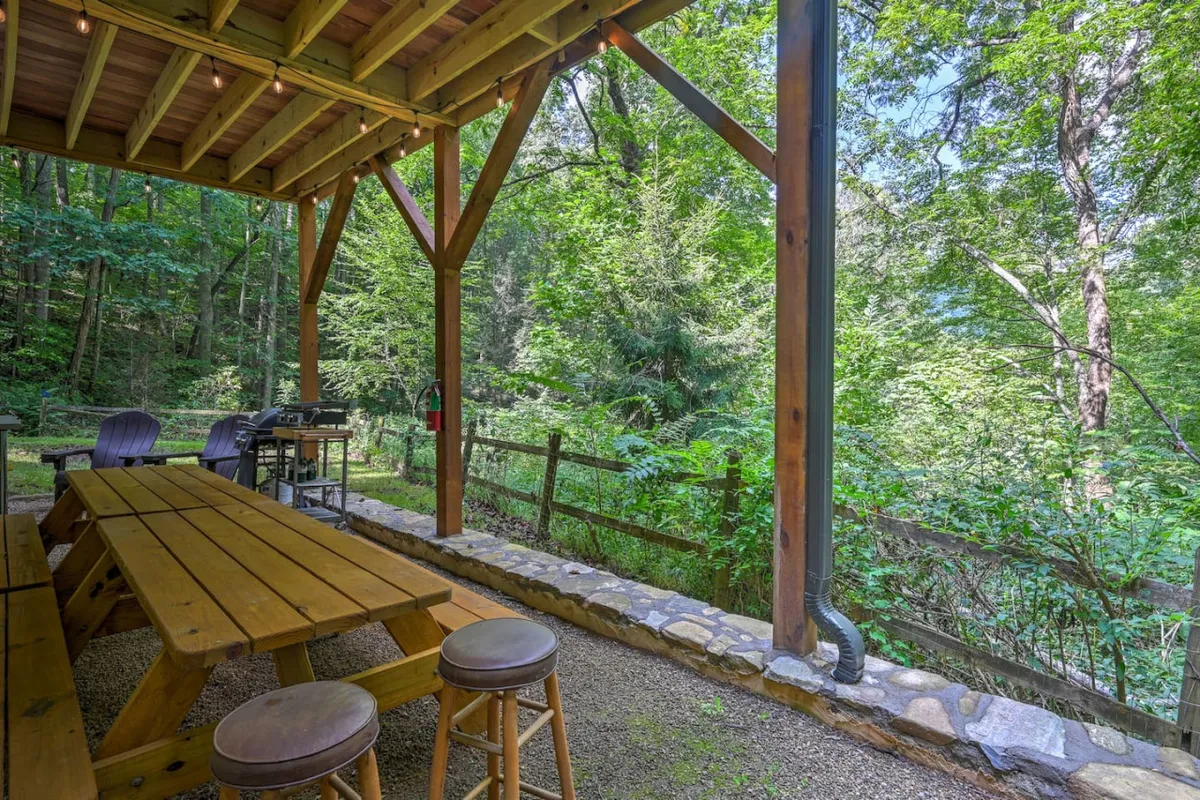 This exterior shot shows a wooden picnic table and grill set amidst lush greenery, inviting families to enjoy outdoor meals and time together. The scene suggests moments of togetherness and casual relaxation.